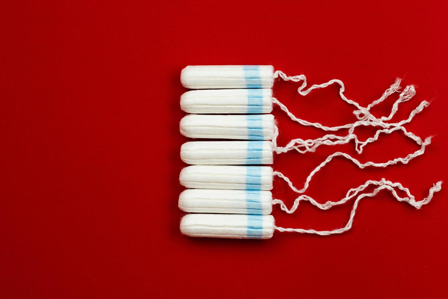 menstruatie concept. vrouw hygiëne bescherming. gezondheid van vrouwen. katoenen tampons op rode achtergrond. foto