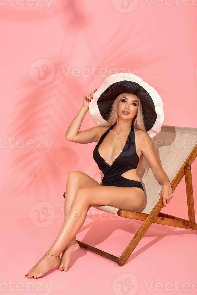 vrouw ontspannende Aan strand stoel. zon bad met hoed, zonnebril en divers uitdrukkingen, studio schot foto