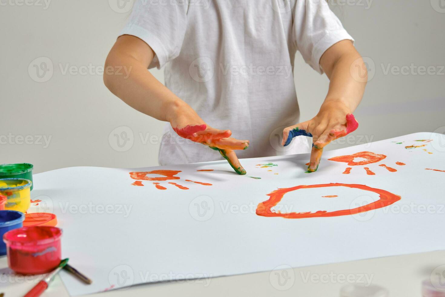weinig artiest in wit t-shirt staand Bij tafel met welke man en kleurrijk verven, schilderij Aan het met haar handen. geïsoleerd Aan wit. detailopname. foto