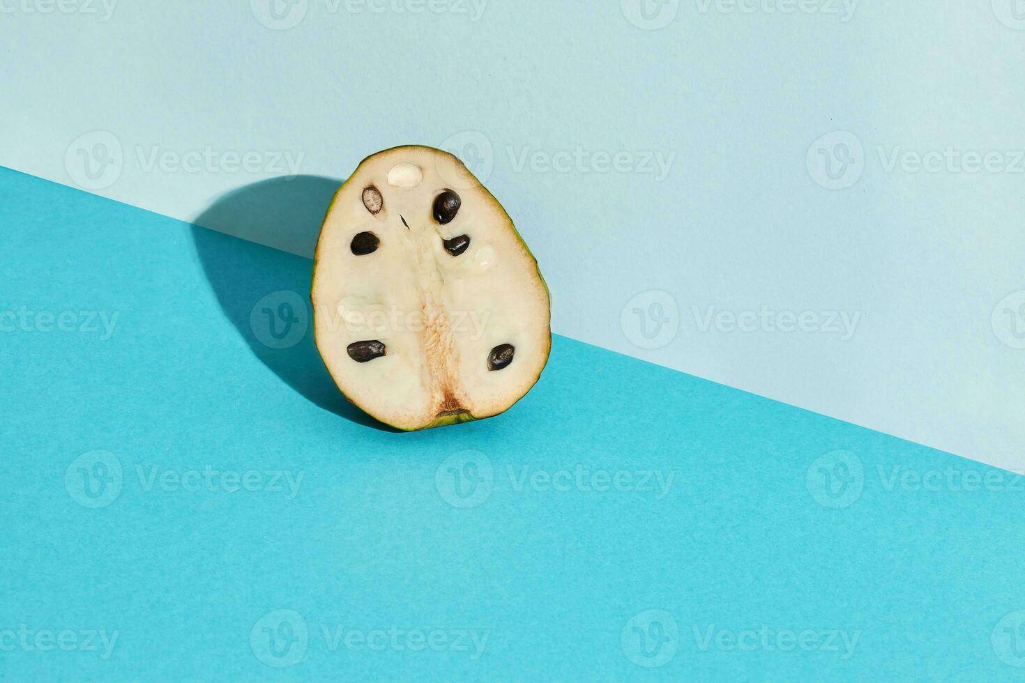 dichtbij omhoog hoog kwaliteit beeld van voor de helft van suikerappel, fruit van annona squamosa cherimoya, fruit samenstelling Aan blauw pastel foto