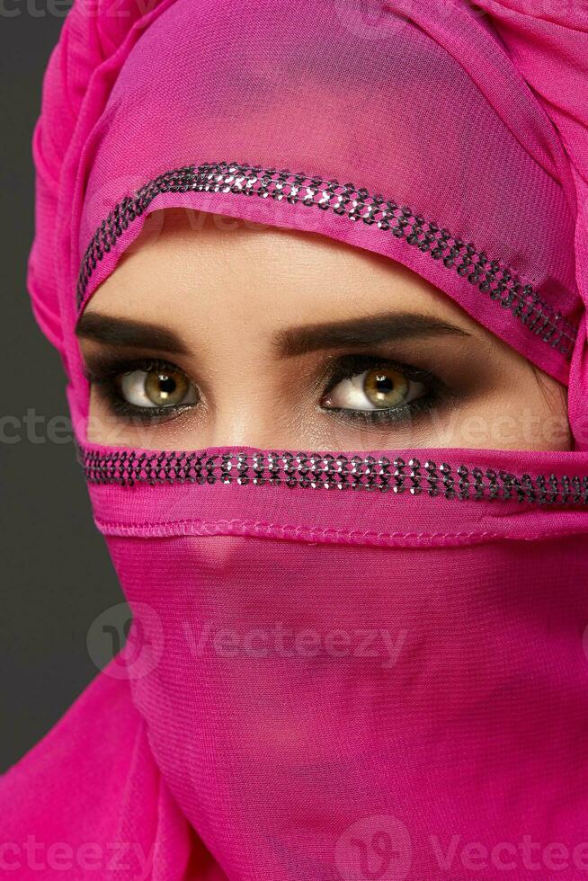 detailopname schot van een jong charmant vrouw vervelend de roze hijab versierd met pailletten. Arabisch stijl. foto