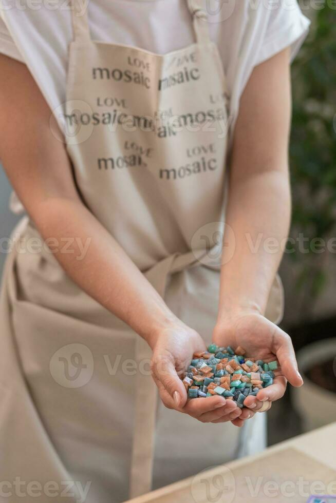 werkplaats van de mozaïek- meester vrouwen handen Holding mozaïek- details in de werkwijze van maken een mozaïek- foto