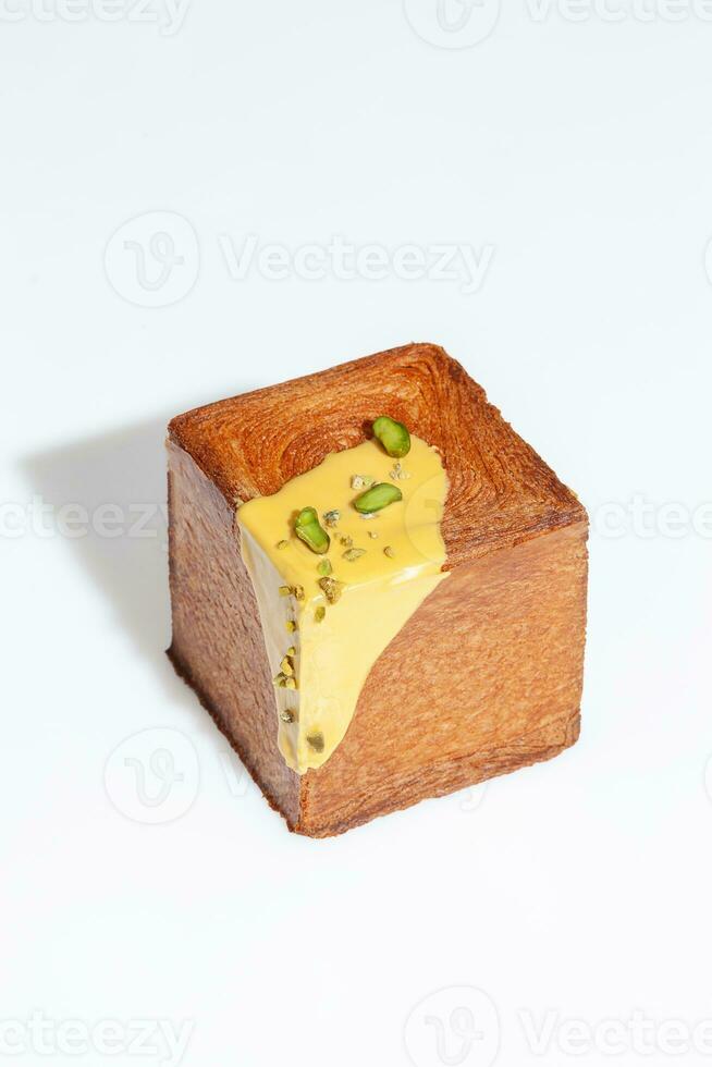 kubus vormig croissant met zoet pistache room en noot kruimels geïsoleerd Aan wit foto