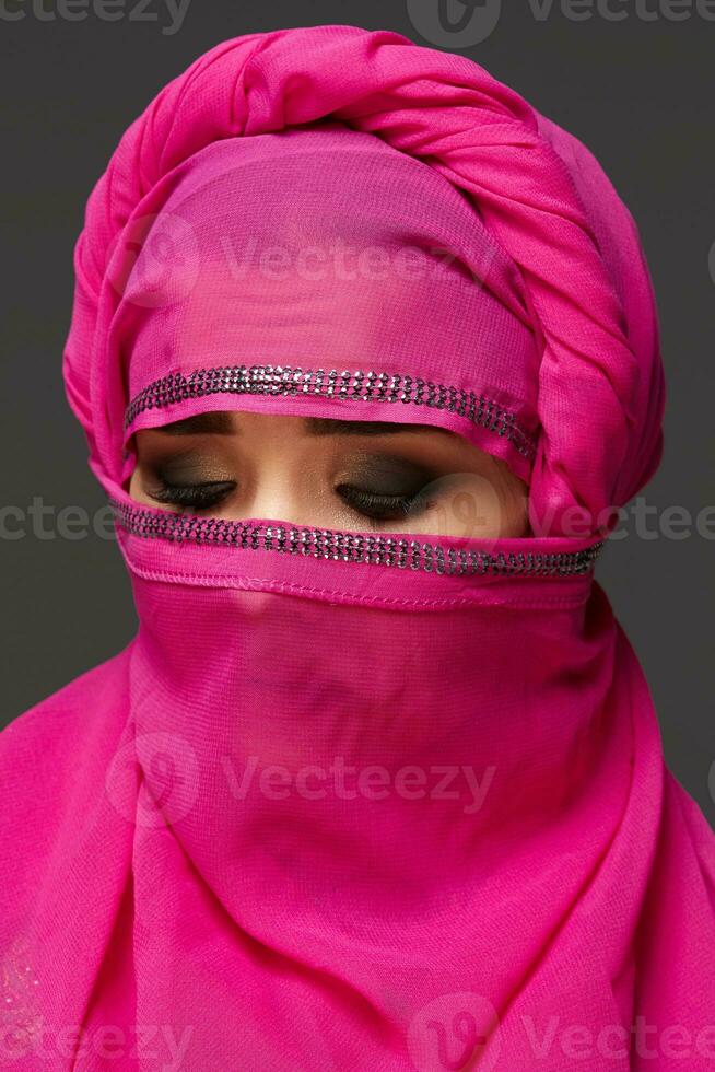 detailopname schot van een jong charmant vrouw vervelend de roze hijab versierd met pailletten. Arabisch stijl. foto