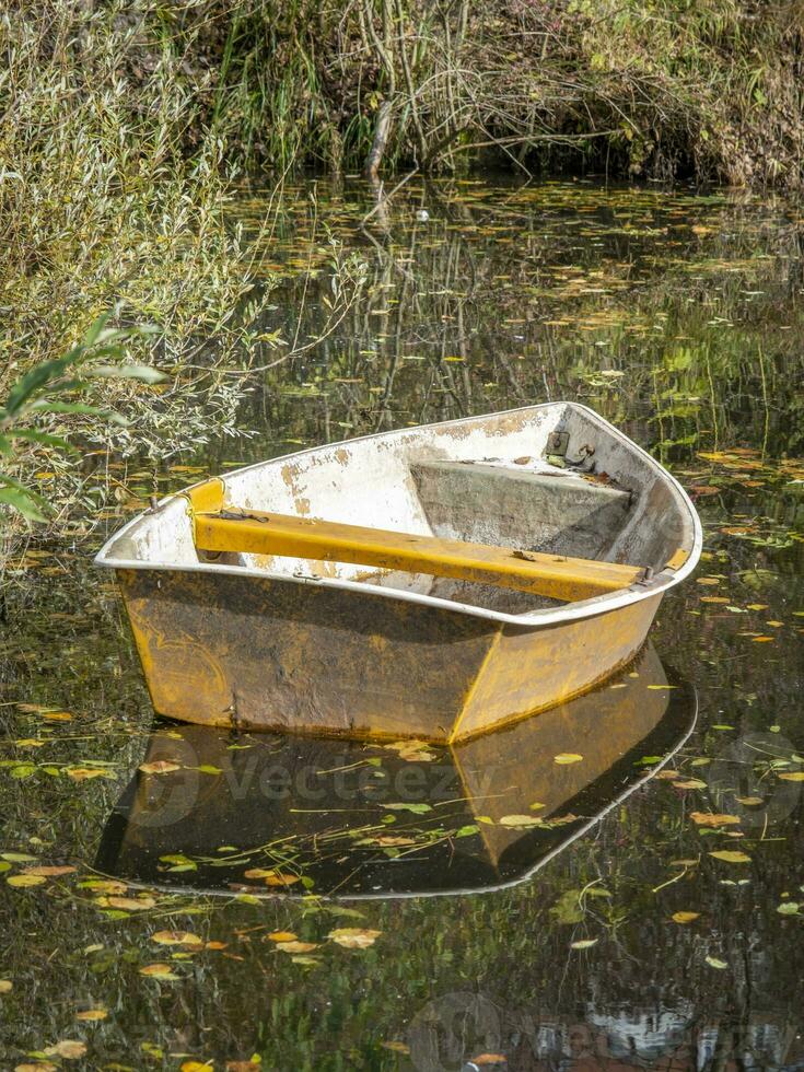 deze foto's shows een boot Aan een klein vijver met reflecties in een boeren dorp in Duitsland foto