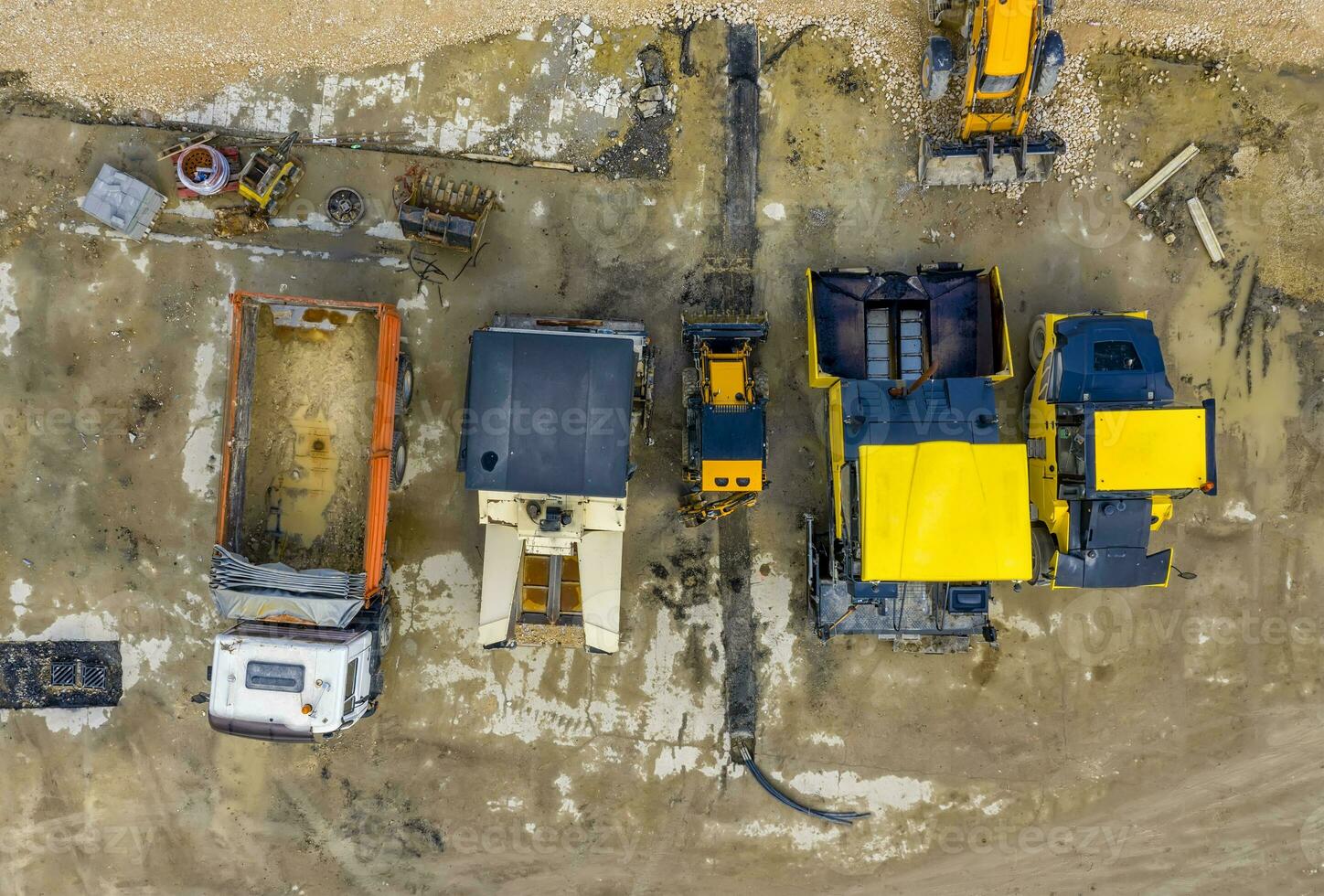 verbazingwekkend antenne visie van asfalt verspreiden machines en vrachtauto Bij een bouw plaats. weg bouw. foto