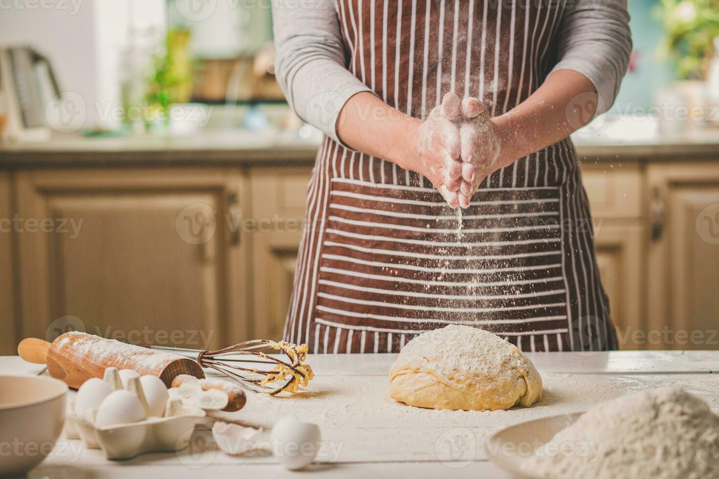 vrouw klap zijn handen bovenstaand deeg detailopname. bakker afwerking zijn bakkerij, schudden meel van zijn handen, vrij ruimte voor tekst. foto