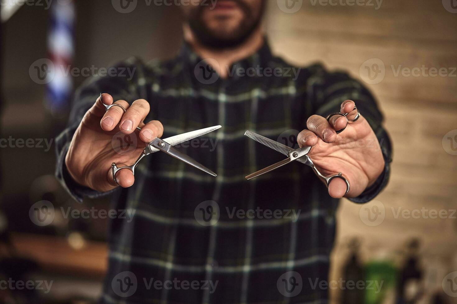 Mens kapper in een plaid overhemd Holding een scherp professioneel schaar. detailopname foto
