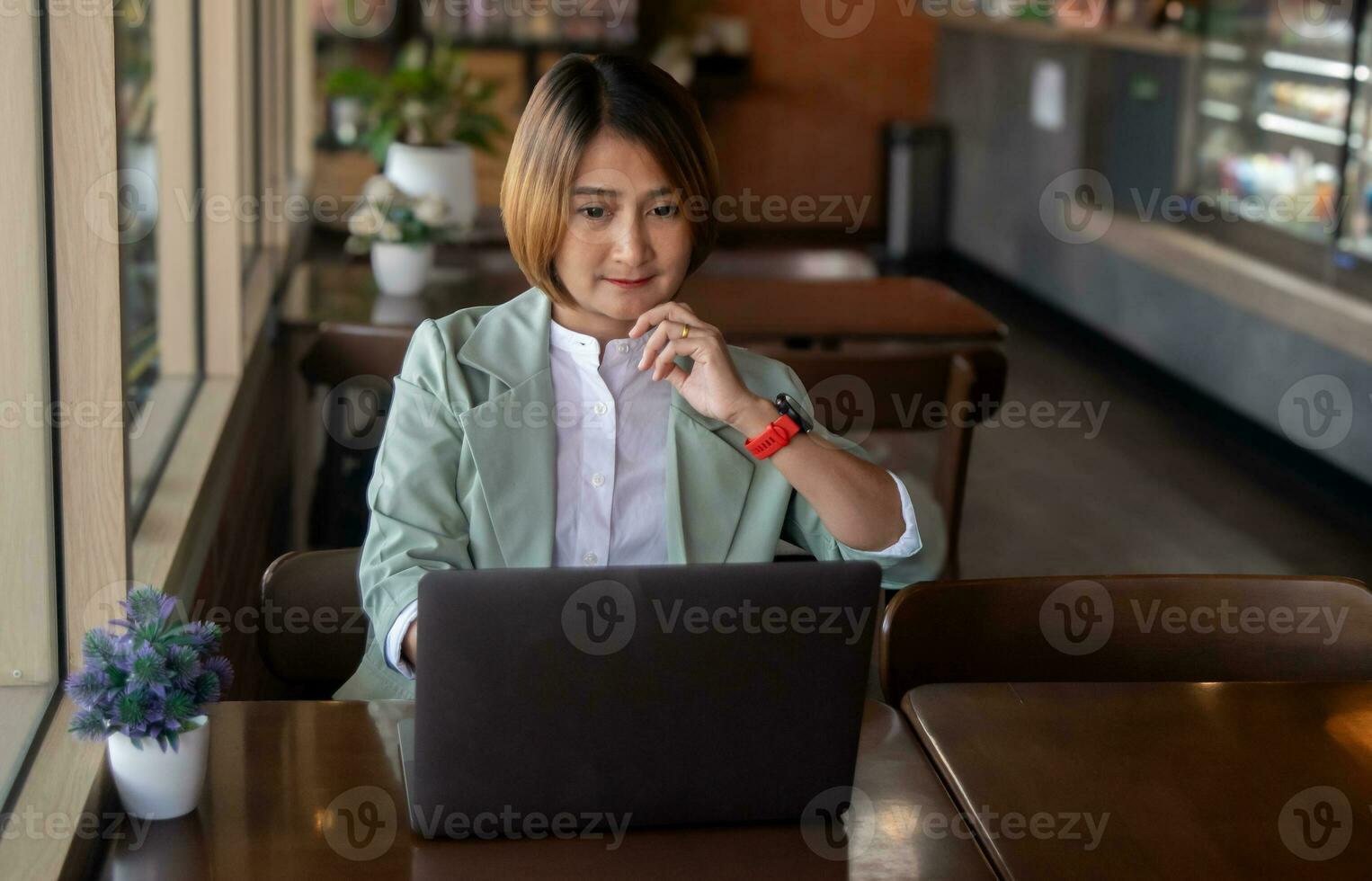 freelance zakenvrouw vervelend pak en zittend Bij de cafe werken Aan laptop gebruik makend van software internet en controle e-mail, ontwikkelen nieuw project concept foto