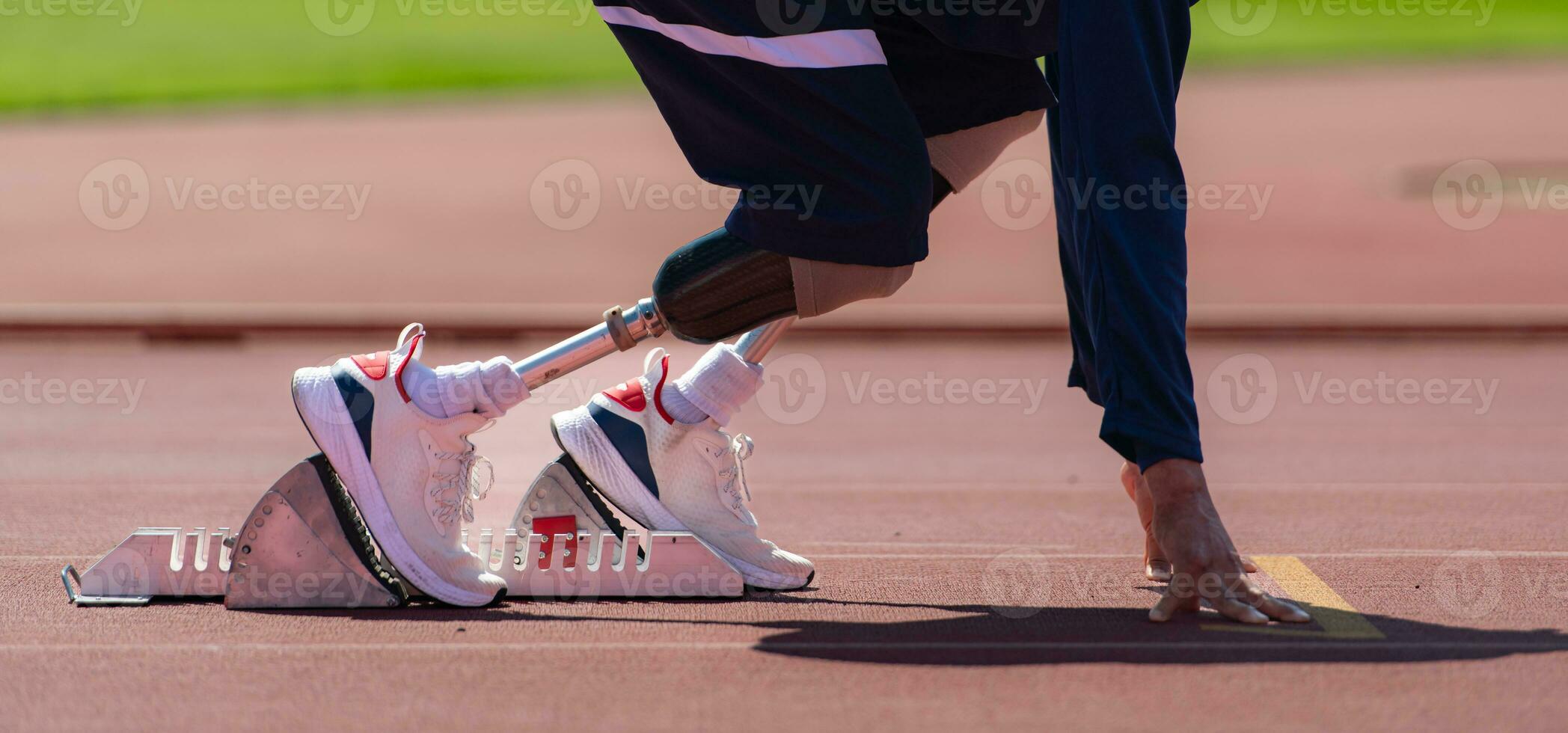 gehandicapt atleten bereiden in beginnend positie klaar naar rennen Aan stadion bijhouden foto