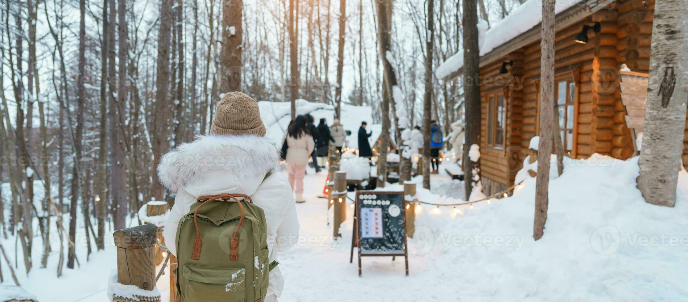 vrouw toerist bezoekende in furano, reiziger in trui bezienswaardigheden bekijken Ningle terras huisjes met sneeuw in winter. mijlpaal en populair voor attracties in hokkaido, Japan. reizen en vakantie concept foto