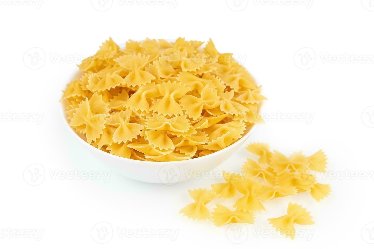 rauw pasta farfalle in kom geïsoleerd Aan wit achtergrond foto