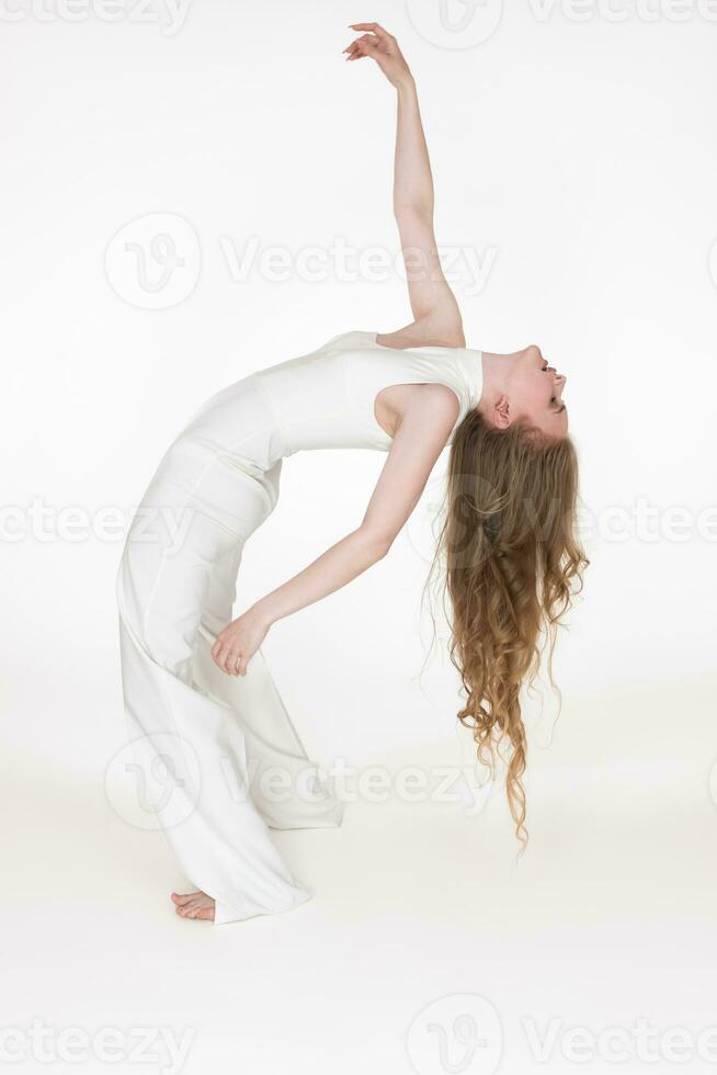 vol lengte visie van flexibel jong vrouw danser buigen over- achteruit met ogen Gesloten. kant visie foto
