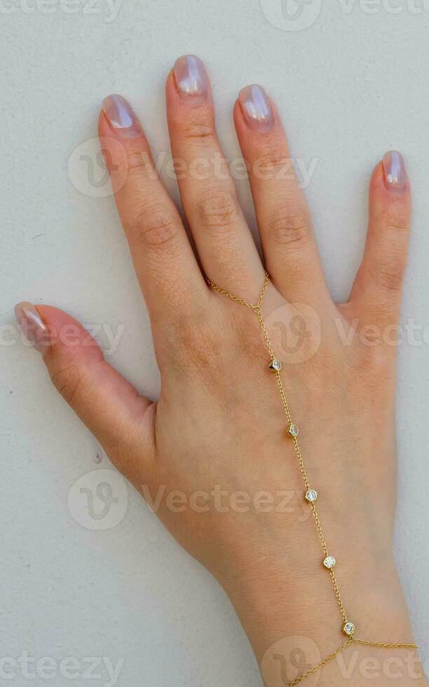 vrouw hand- pols vervelend gouden hand- keten reeks tegen een wit achtergrond. foto