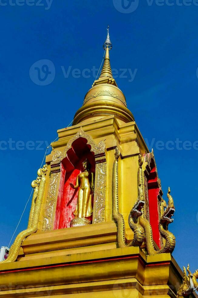 een gouden Boeddha standbeeld Aan top van een gebouw foto
