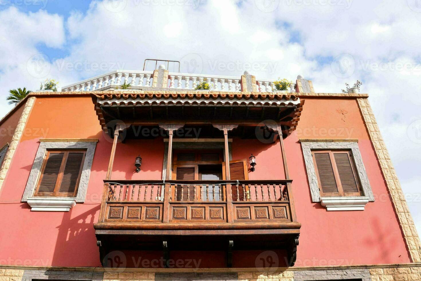 een rood gebouw met een houten balkon foto