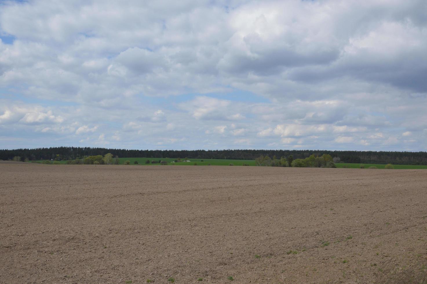 panorama van een lenteveld dat door een tractor wordt gewied foto