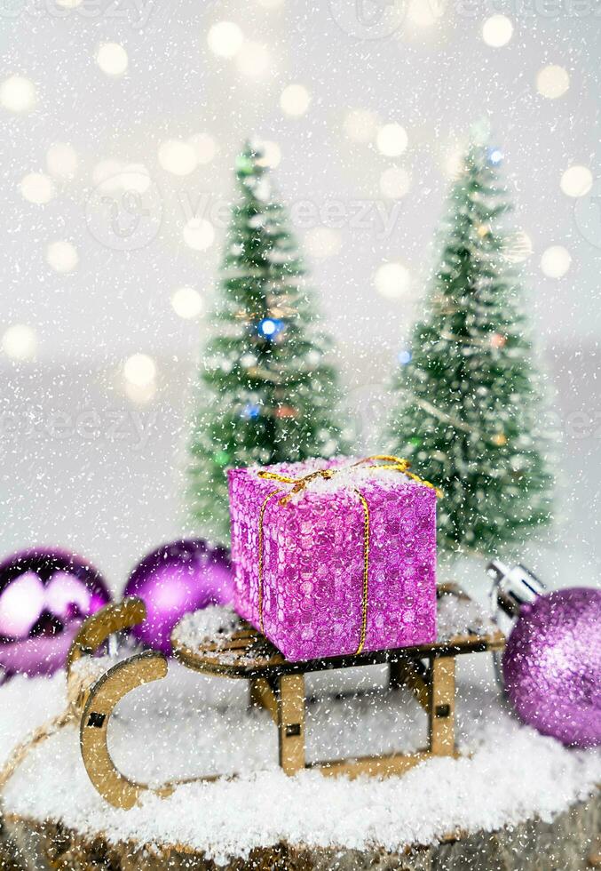 Kerstmis geschenk Aan een decoratief slee Aan de sneeuw. nieuw jaar kaart. detailopname. selectief focus. foto