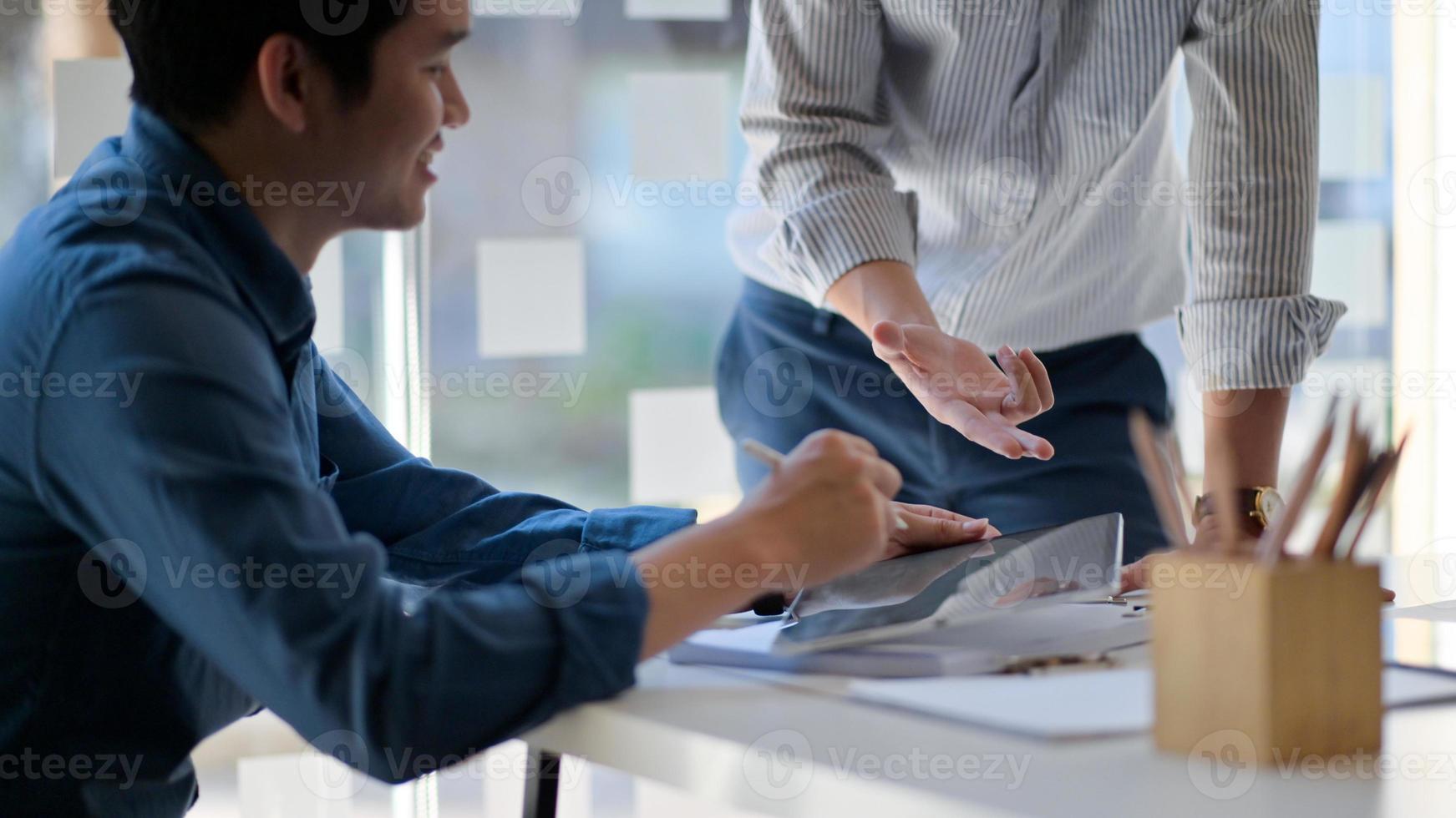 twee jonge mannen die op kantoor een project bespreken, zijn in een goed humeur. foto