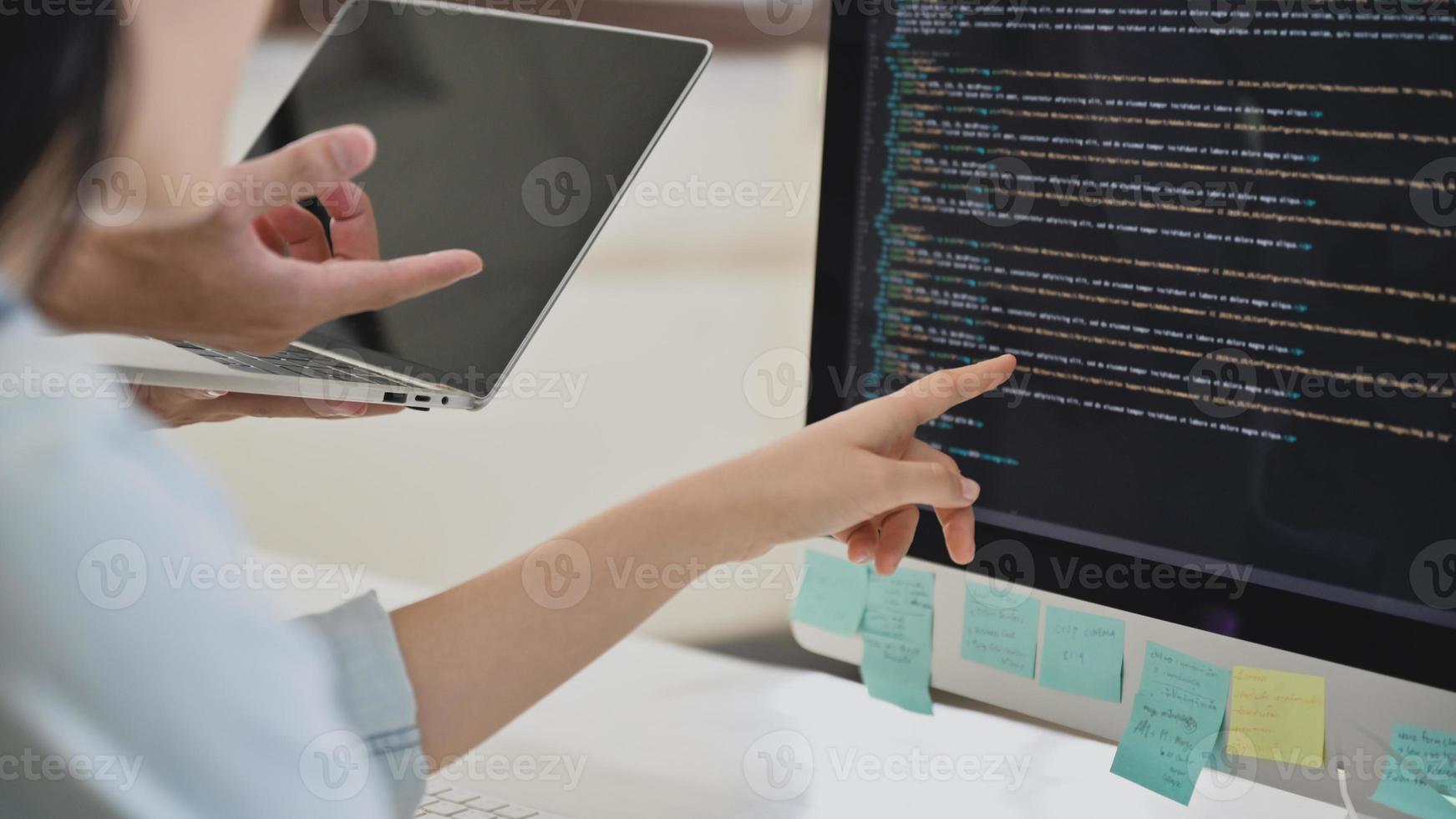 een team van programmeurs controleert de code op het computerscherm. foto
