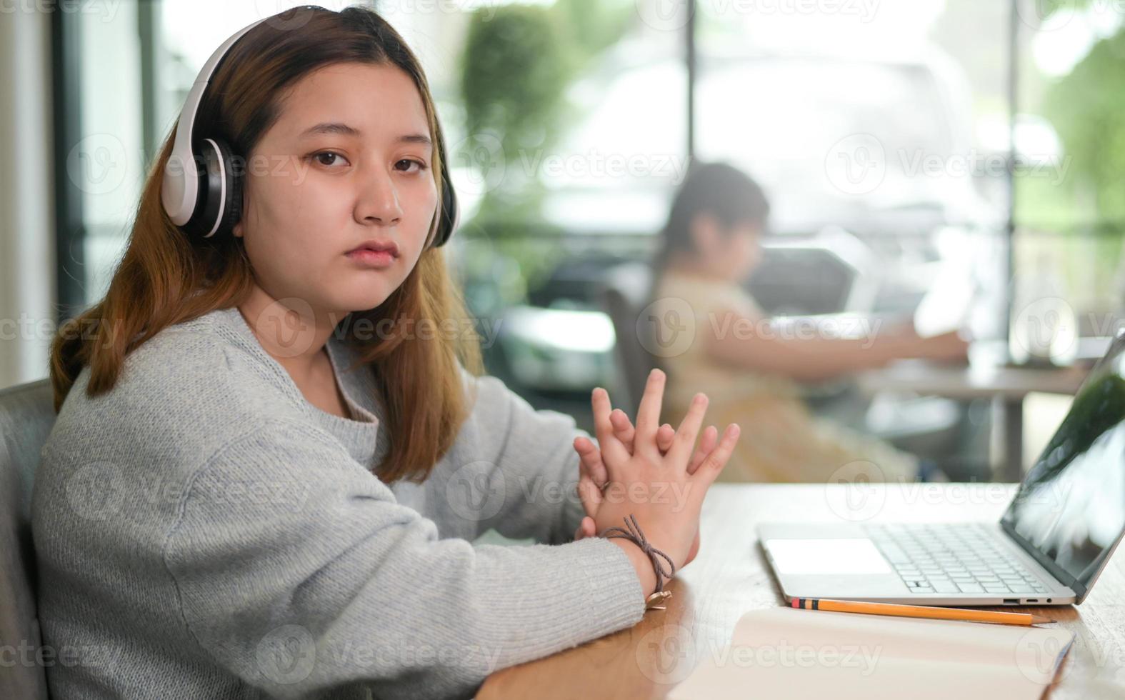 jonge vrouwelijke studenten rusten terwijl ze laptops gebruiken om online te studeren, meisje ziet er uitgeput uit. foto