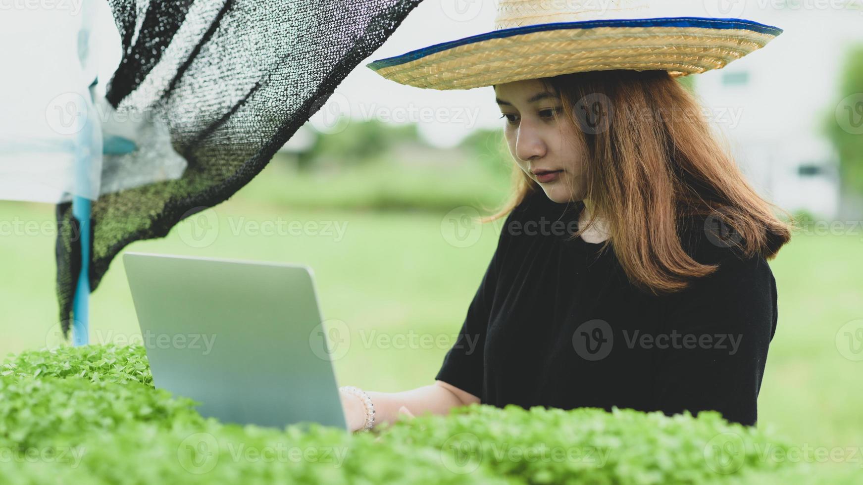 een nieuwe generatie vrouwelijke boeren met laptop in de hydrocultuurplantage in kas, slimme boerderij. foto