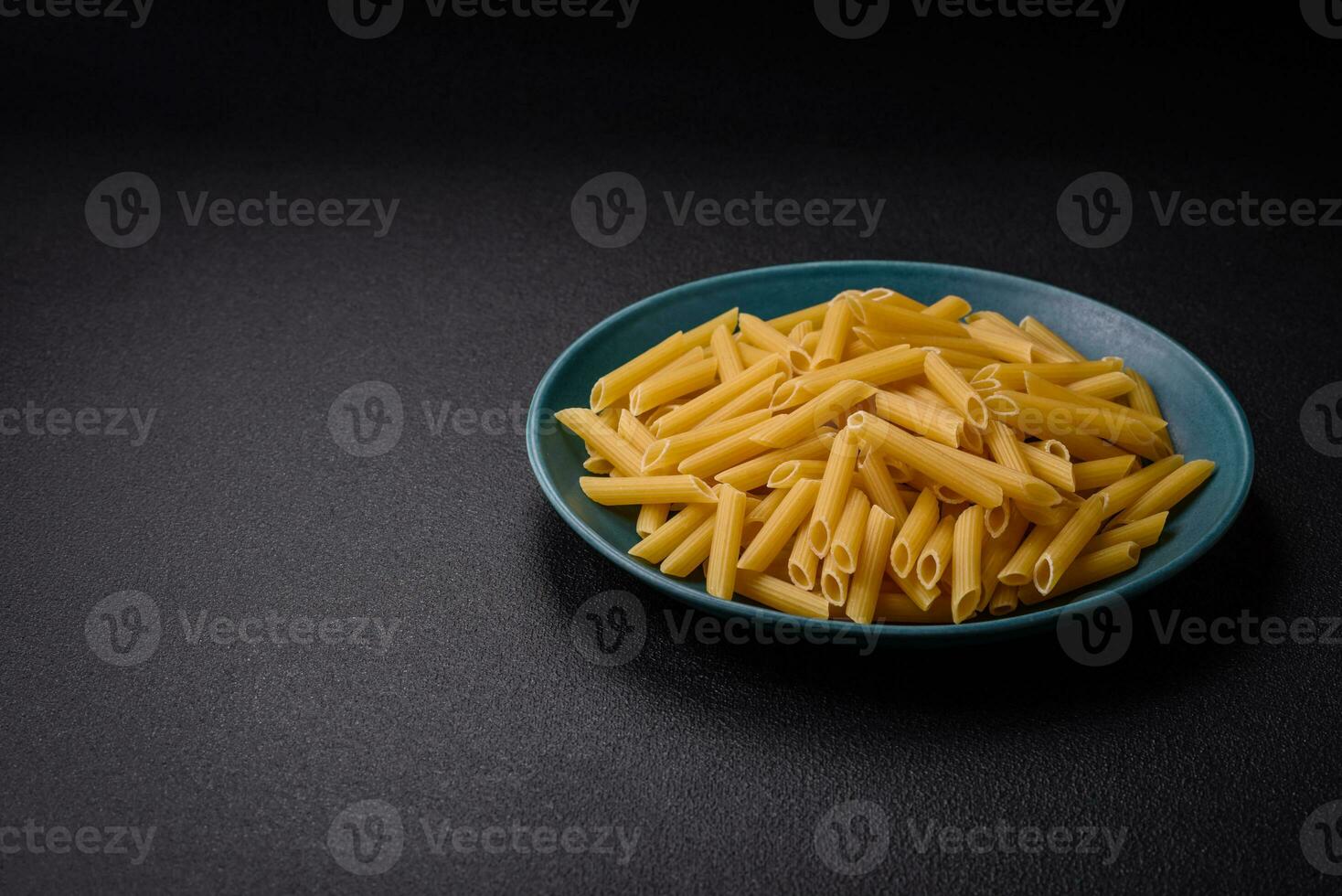 rauw penne pasta van geheel graan tarwe variëteiten met zout en specerijen foto