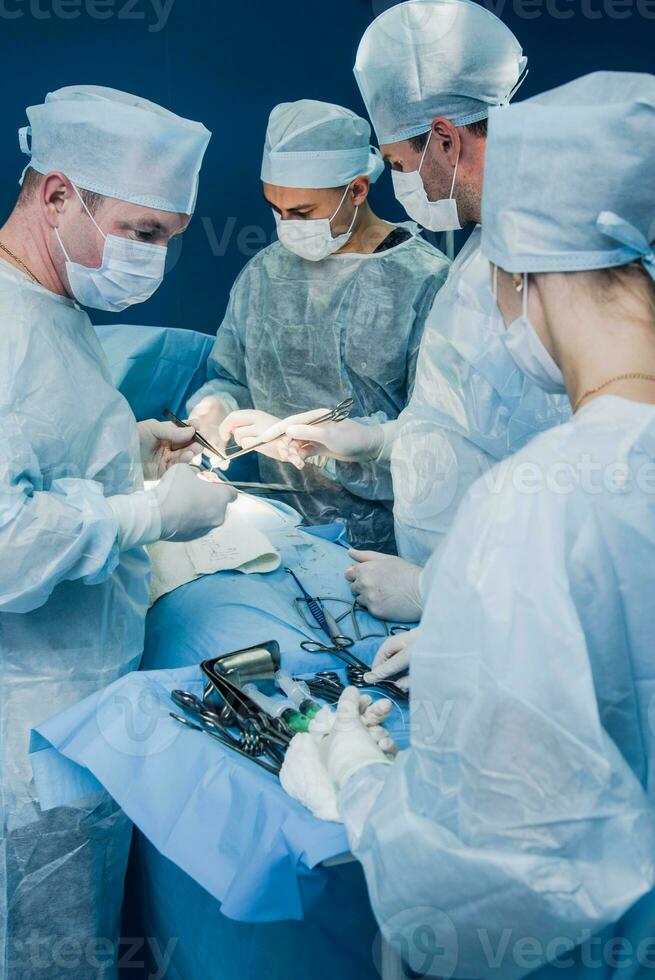 team van chirurgen aan het doen operatie in ziekenhuis foto