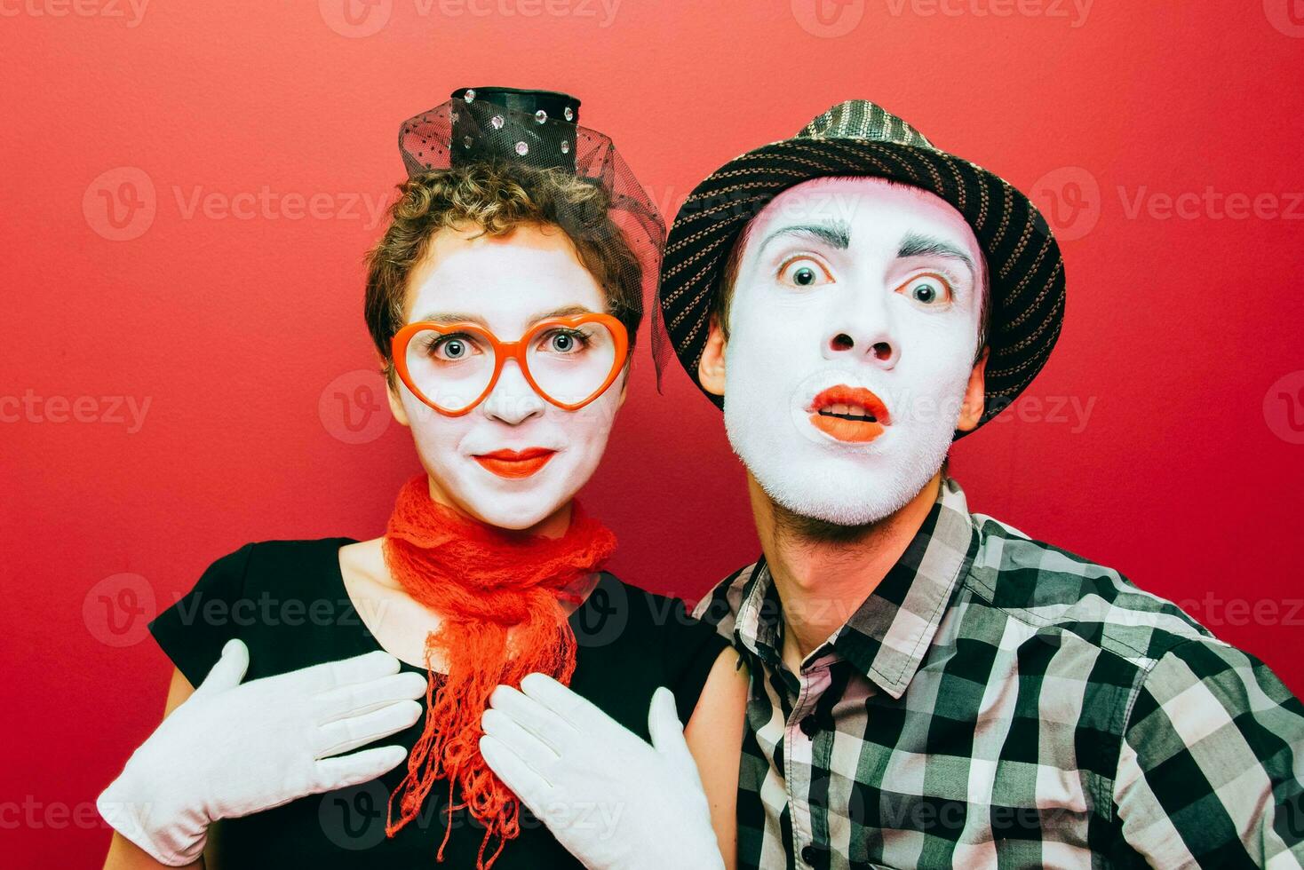 twee mimespelers poseren tegen een rood muur achtergrond foto