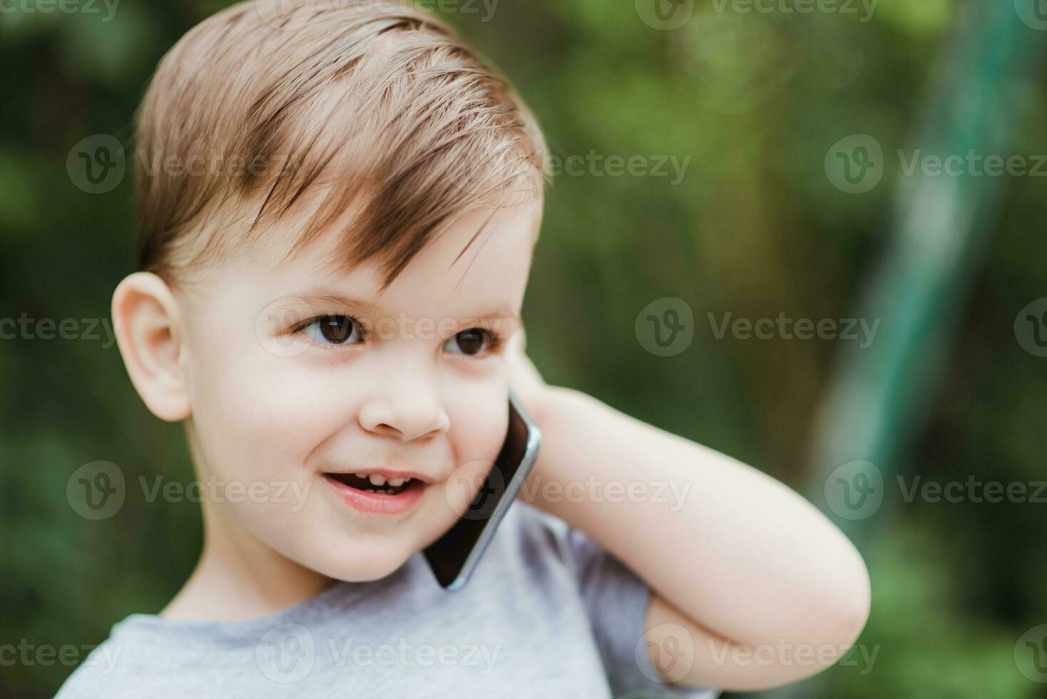 weinig baby is pratend Aan de telefoon in de straat foto