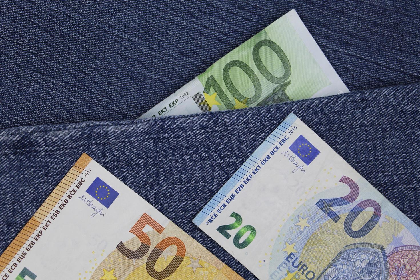 Europese bankbiljetten van verschillende benamingen tussen blauwe denimstof; foto