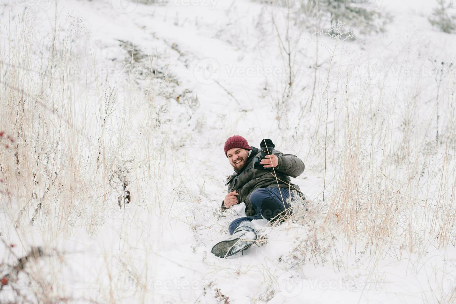 vrolijk reiziger fotograaf uitgegleden en viel Aan sneeuw foto