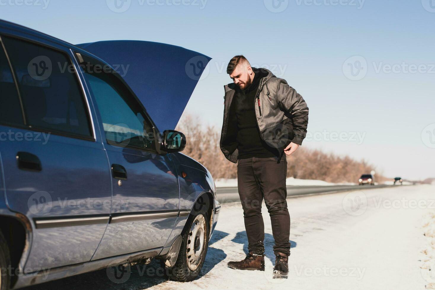 Mens repareren een auto staand Bij de kap foto
