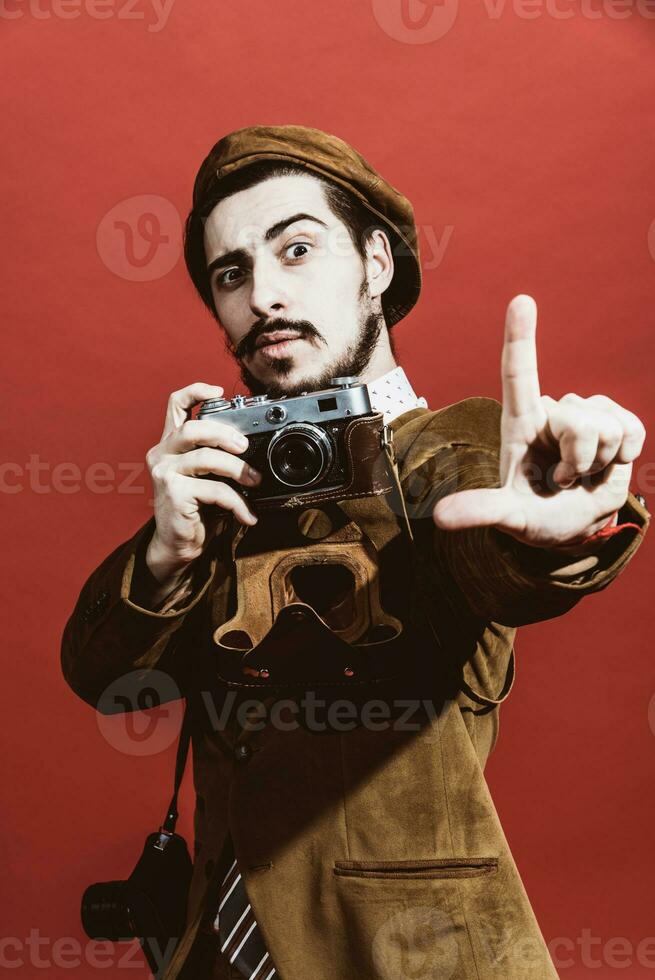 heel positief fotograaf poseren in studio met film camera foto