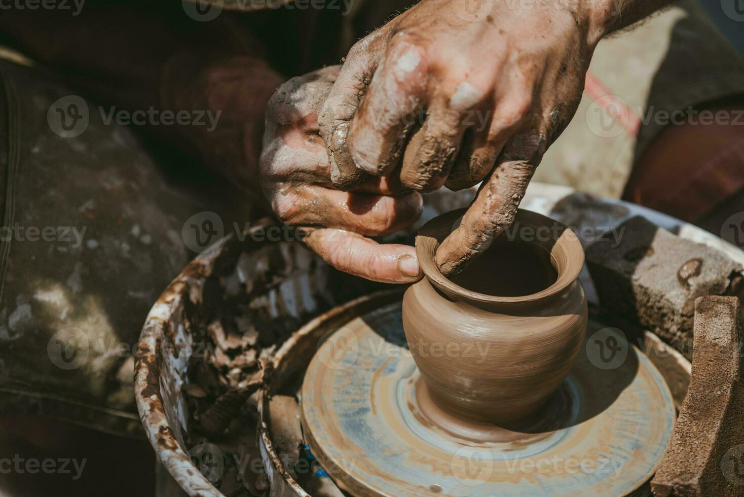 meester handen maakt een pot van klei. meester klasse is gehouden in natuur, detailopname foto