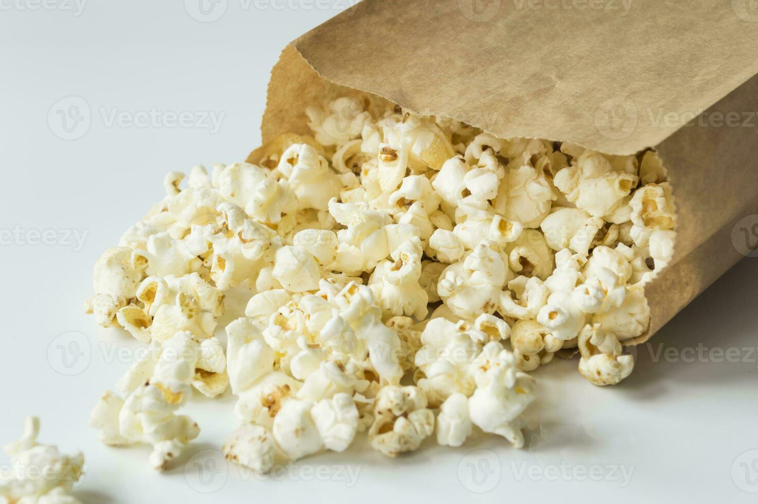 popcorn in een bruin papier zak Aan een wit oppervlakte foto