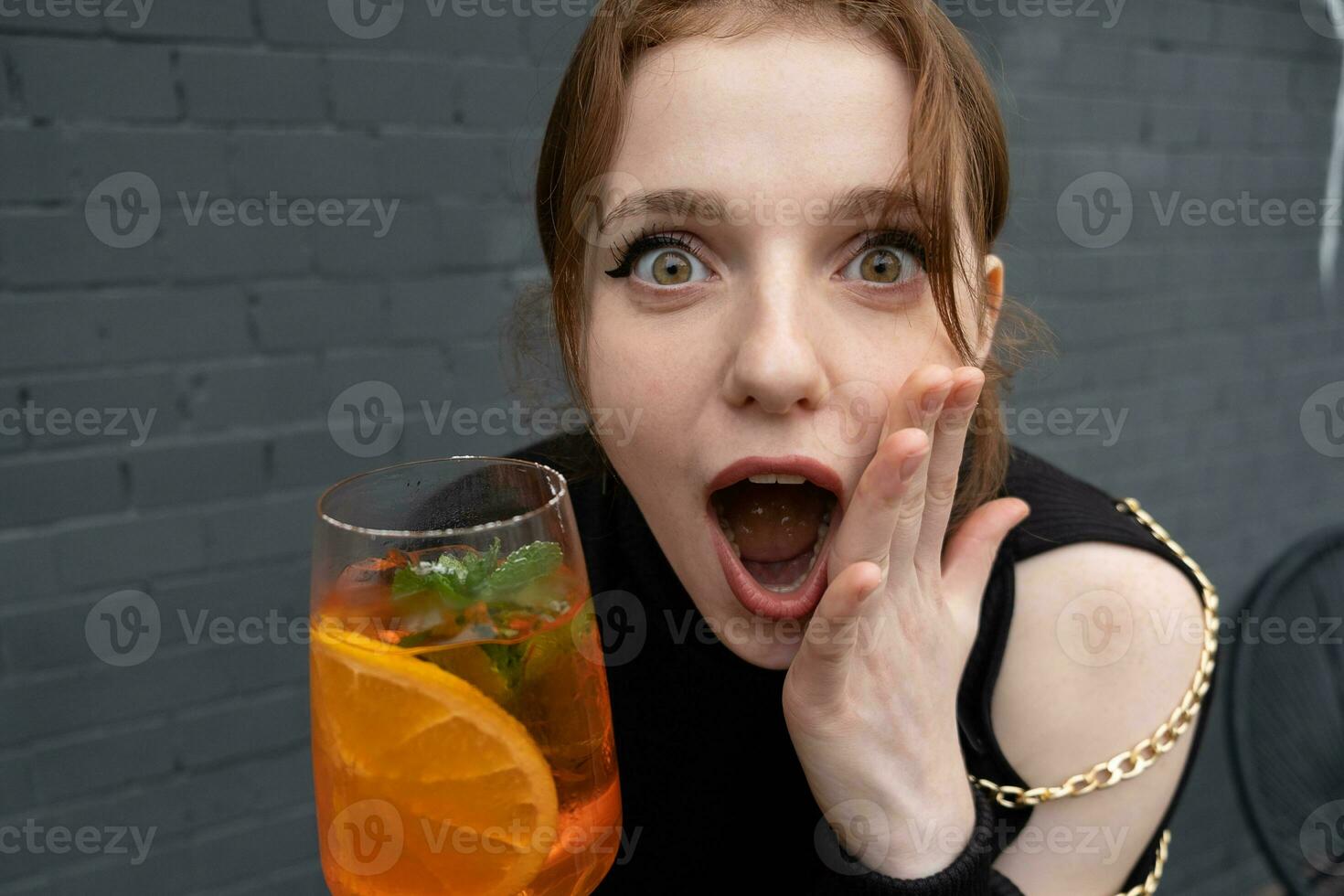 portret van een mooi pret Wauw uitdrukking jong vrouw met een glas van cocktail foto