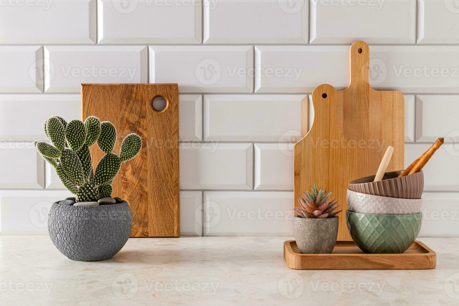 reeks van keramisch kommen en snijdend borden Aan steen licht aanrecht in modern keuken met ingemaakt opuntia, cactus . voorkant visie. minimalisme. foto