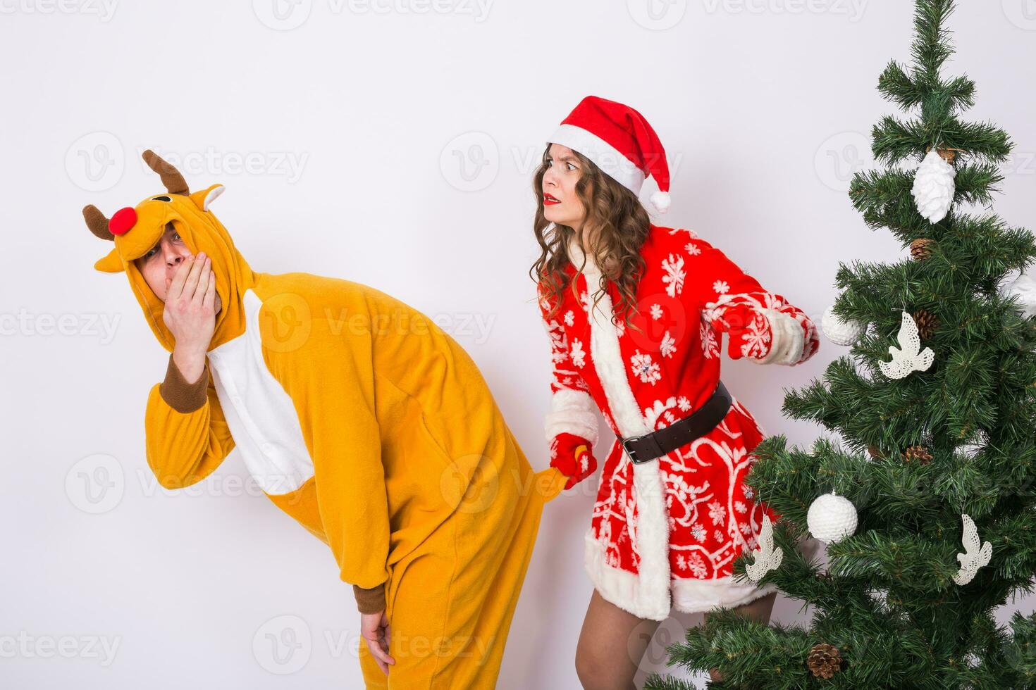 grappig jong vrouw in de kerstman claus hoed en Mens in carnaval kostuum van hert. plezier, vakantie, grap en Kerstmis concept foto