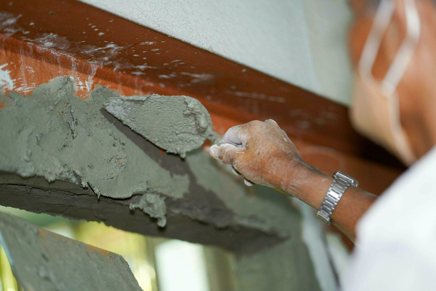 detailopname handen van bouwer Holding Mortier pan en bepleistering muren met cement in bouw plaats. foto