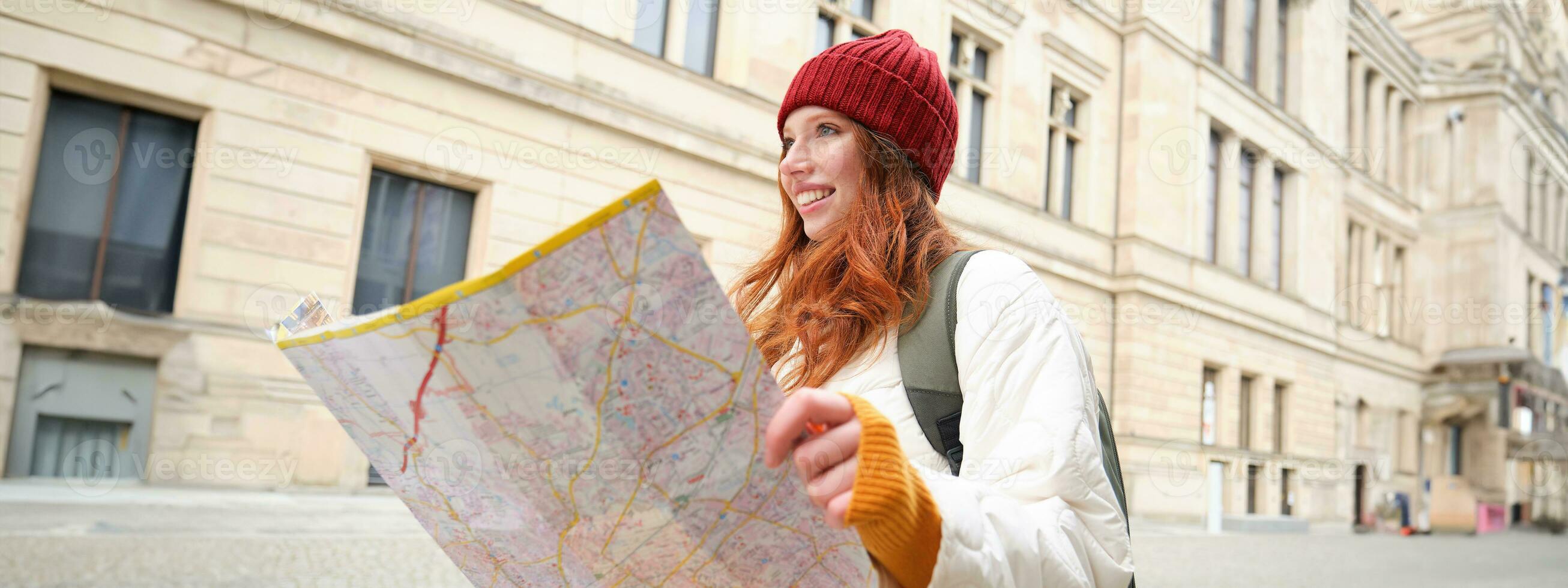 roodharige meisje, toerist onderzoekt stad, looks Bij papier kaart naar vind manier voor historisch oriëntatiepunten, vrouw Aan haar reis in de omgeving van Europa zoekopdrachten voor bezienswaardigheden bekijken foto