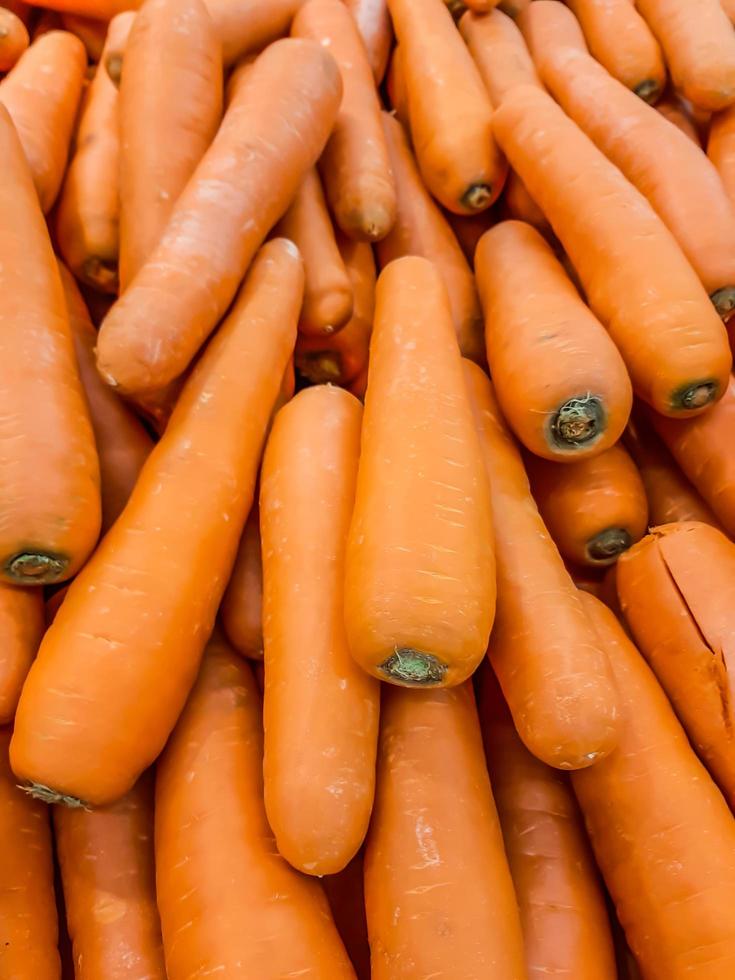 biologische wortel. textuurachtergrond van verse grote oranje wortelen, wortelen zijn goed voor de gezondheid, gezonde rijpe wortel voor het bereiden van maaltijd foto