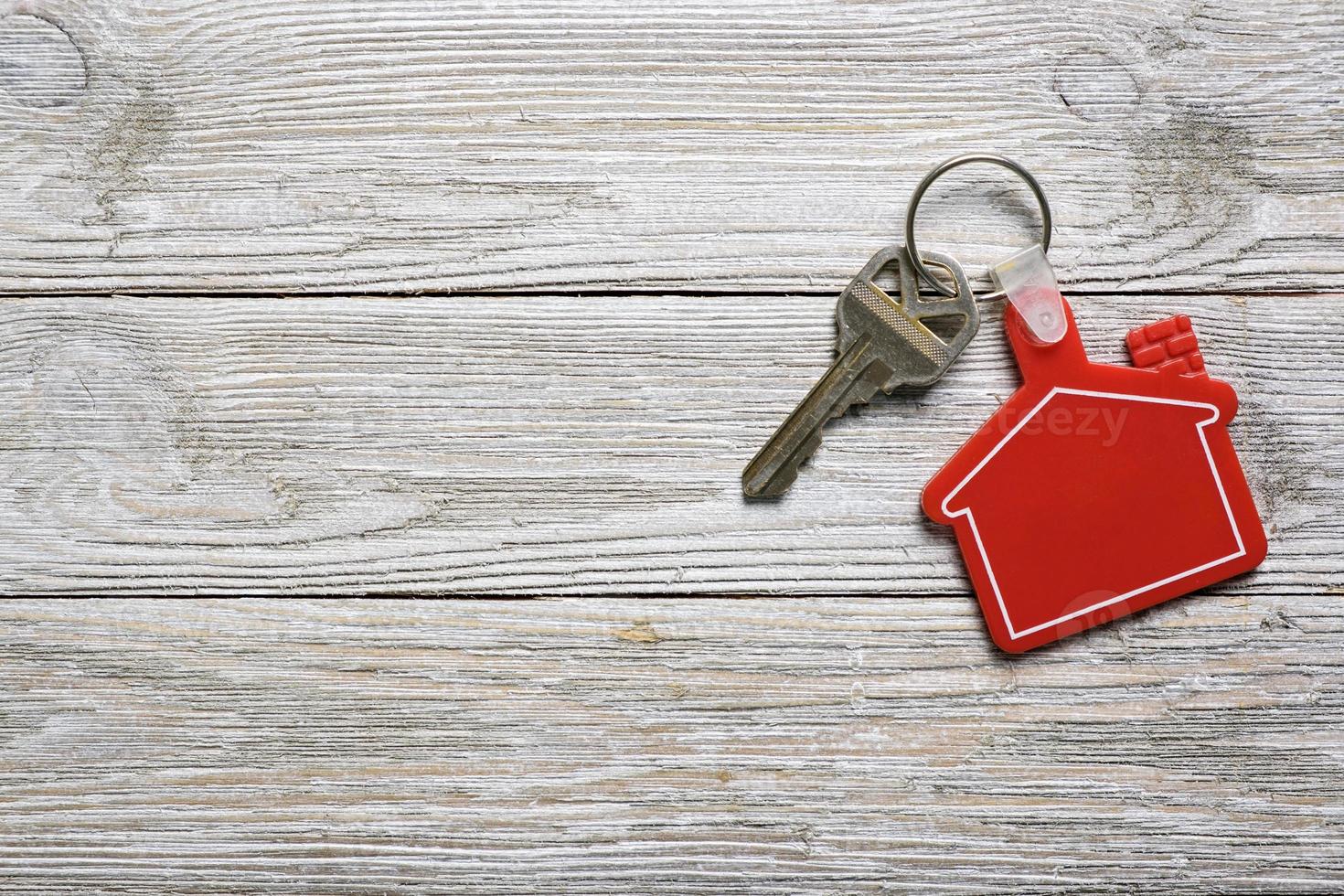huissleutel met rode huisvorm sleutelhanger voor onroerend goed concept foto
