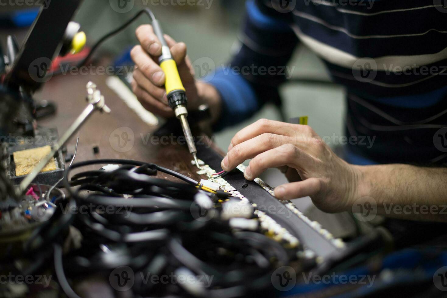 een Mens werken Aan een computer met een solderen ijzer foto