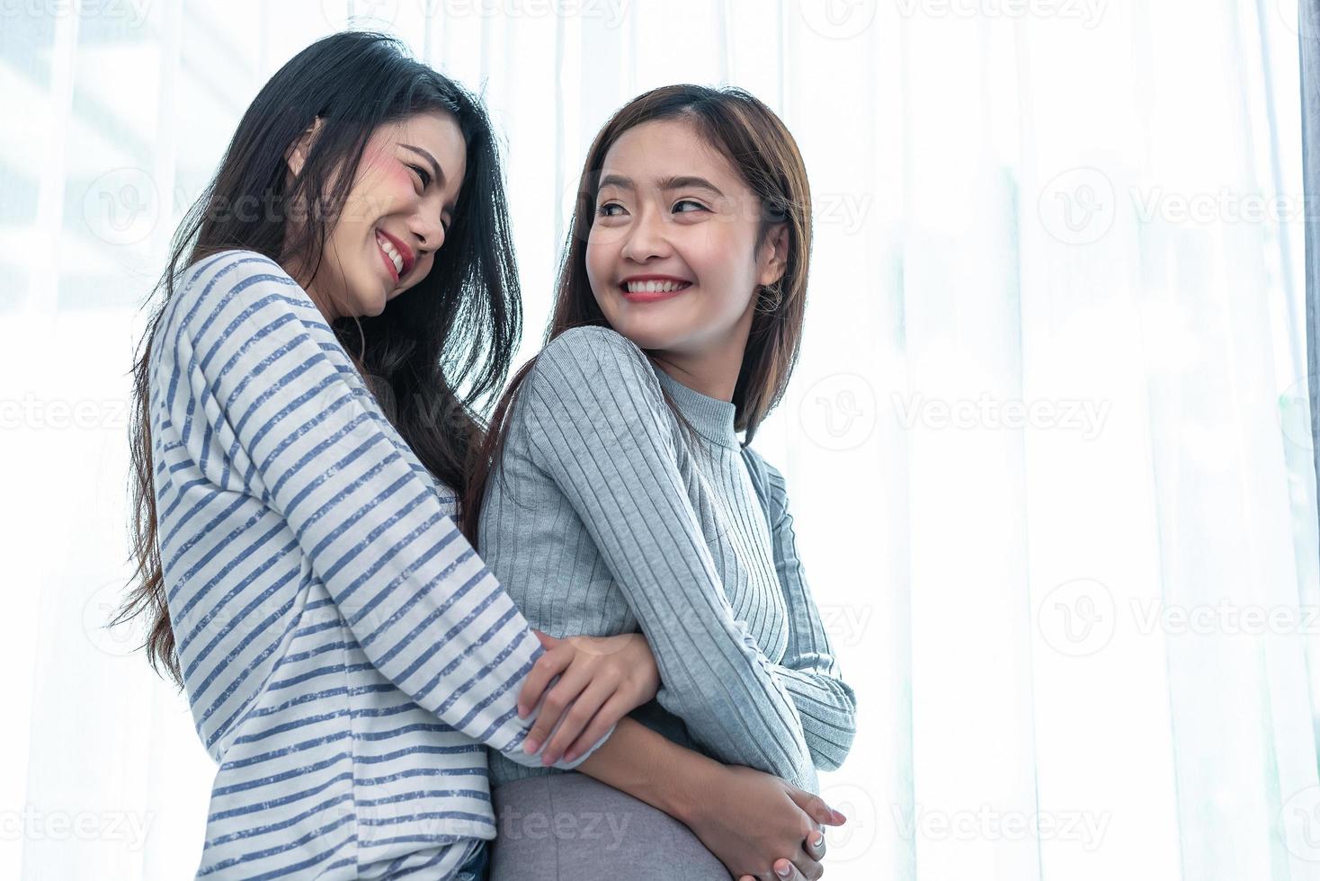 twee Aziatische lesbische vrouwen knuffelen en omhelzen samen in de slaapkamer. paar mensen en schoonheidsconcept. gelukkige levensstijl en home sweet home thema. homoseksueel levensthema. liefdesscène maken van vrouw foto