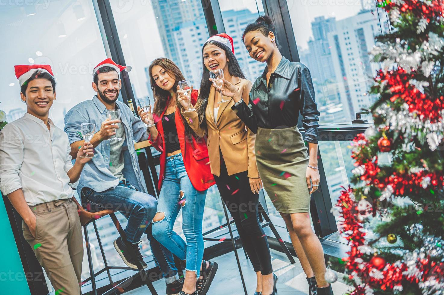 groep zakelijke diversiteit collega teamwerk vieren voor nieuwjaarsfeest in moderne stedelijke kantoorachtergrond. vrienden die samen genieten van een feestje met alcoholivd. multi-ethiek mensen levensstijl foto