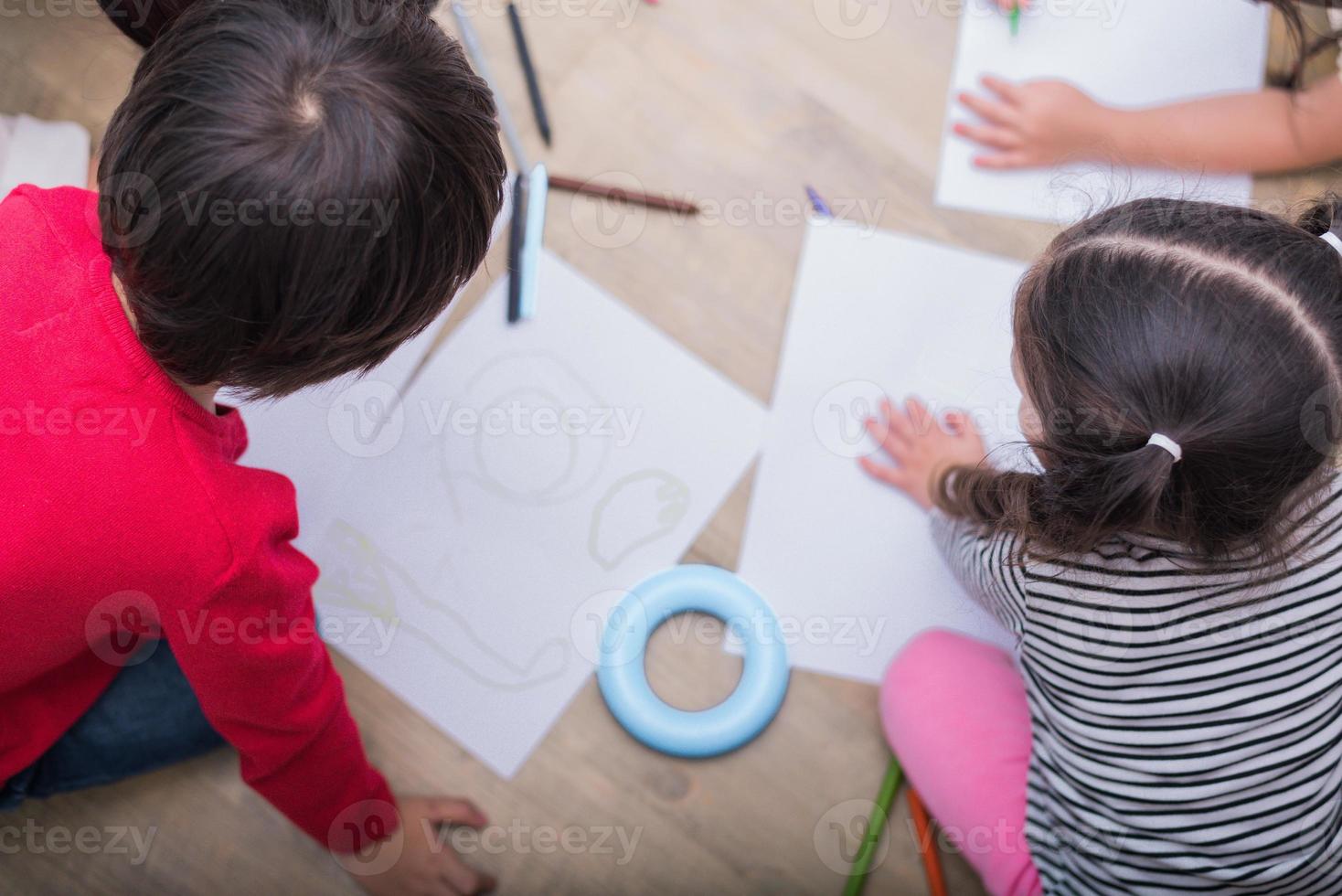 groep voorschoolse student en leraar tekenen op papier in de kunstles. terug naar school en onderwijsconcept. mensen en levensstijlen thema. kamer in de kinderkamer foto