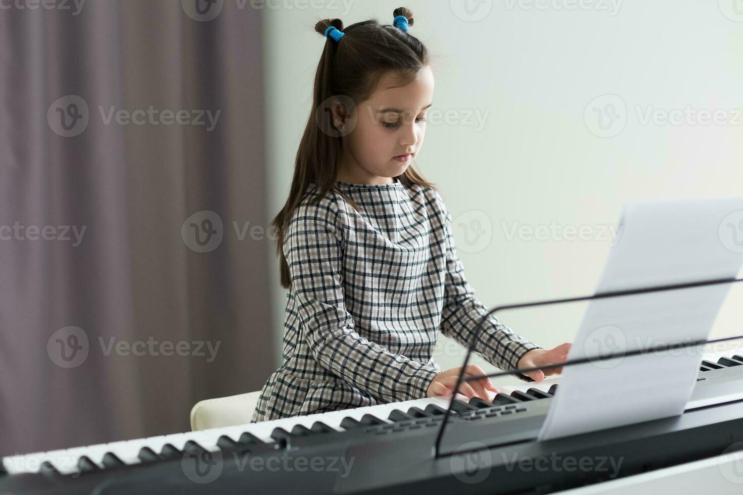 schattig weinig meisje Toneelstukken Aan piano, synthesizer. opleiding. onderwijs. school. esthetisch opleiding. elementair klas. foto