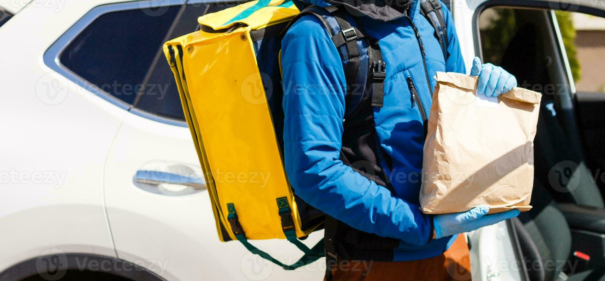 contactloos voedsel levering naar klanten huis. levering onderhoud arbeider met thermisch rugzak snel leveren voedsel Bij drempel in quarantaine van restaurant, supermarkt of cafe . online bestellen voedsel foto