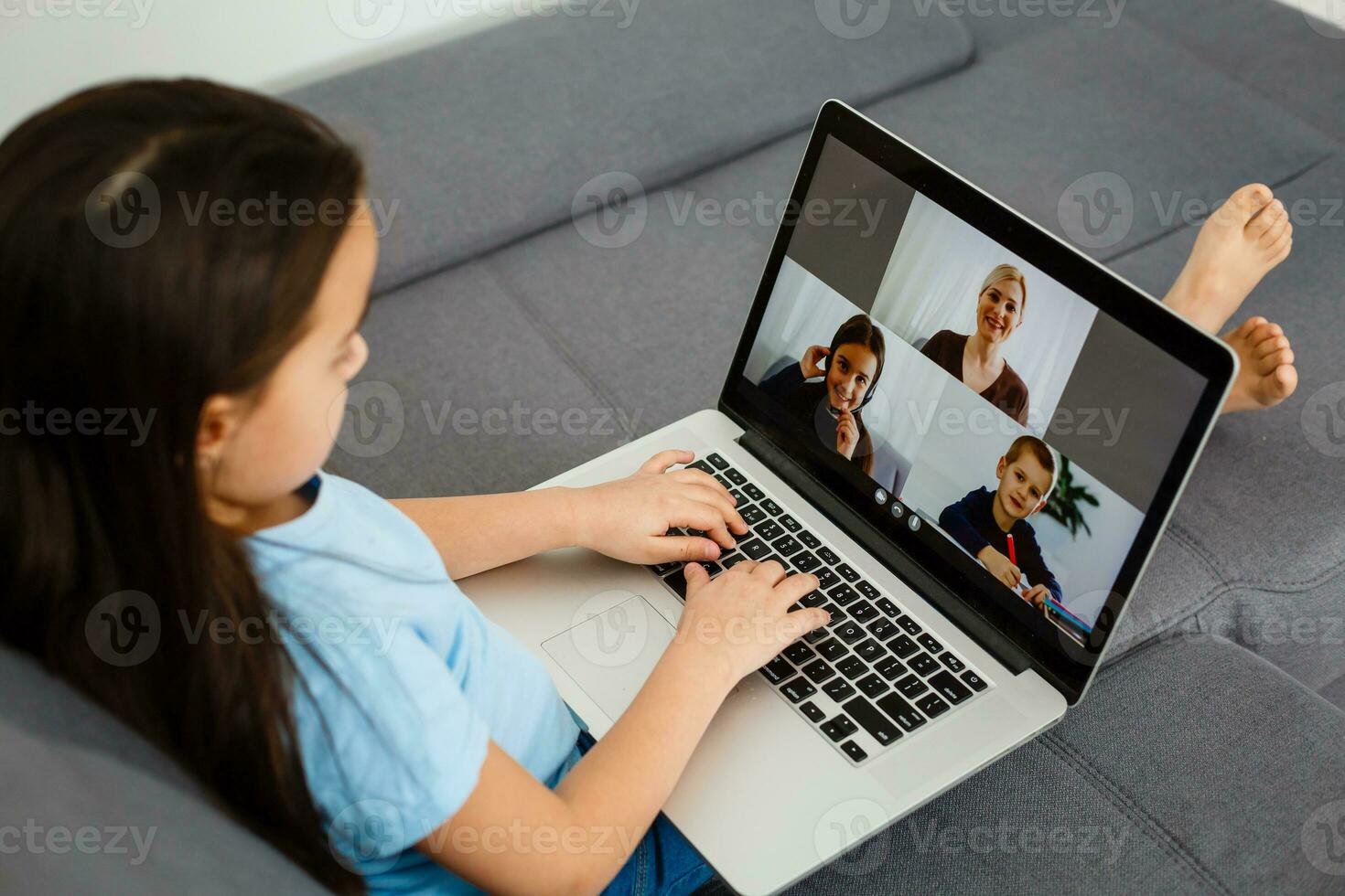 schattig weinig meisje gebruik makend van laptop Bij huis. opleiding, online studie, huis aan het studeren, afstand aan het leren, schoolmeisje kinderen levensstijl concept foto